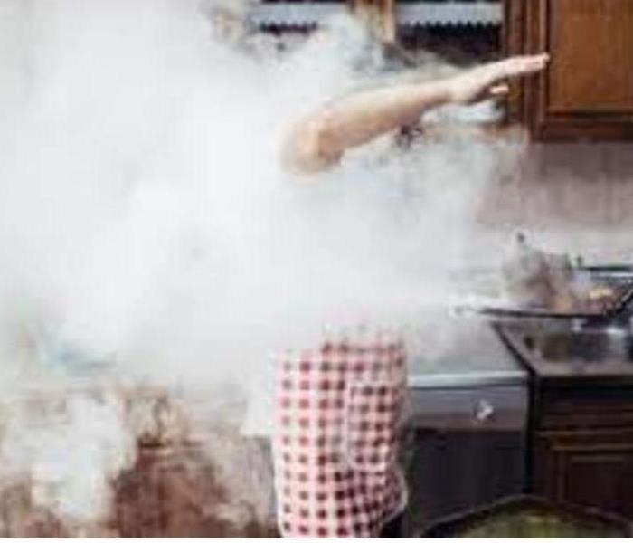 a man standing in a smoked filled kitchen