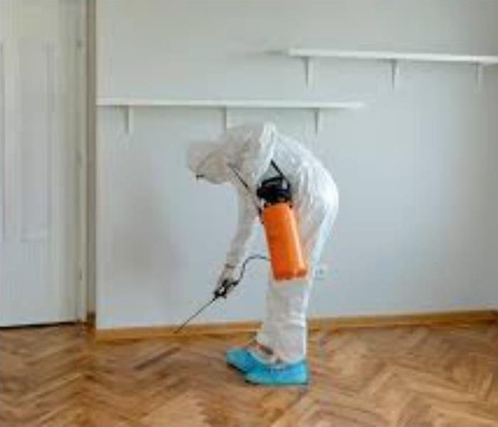 Man in bio hazard suit cleaning